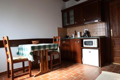 a small kitchen with a table and a microwave at Rábagyarmati Apartman II in Rábagyarmat