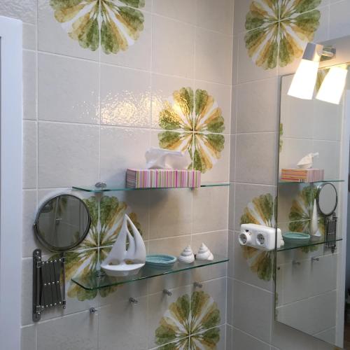 a bathroom with glass shelves with shoes and plants at Haus Solymar App. Meerblick in Grömitz