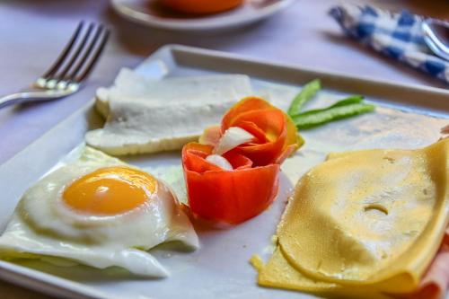 a plate of food with an egg and peppers on it at Casa Colonial Koenig in São Filipe