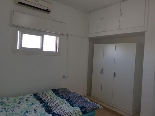 sypialnia z łóżkiem, oknem i białymi szafkami w obiekcie Family house bahai gardens w mieście Hajfa
