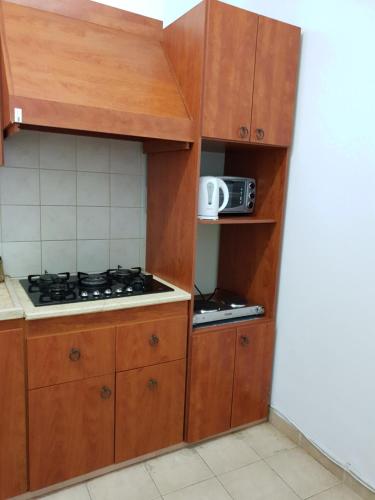 - une cuisine avec des placards en bois et une cuisinière dans l'établissement Family house bahai gardens, à Haïfa