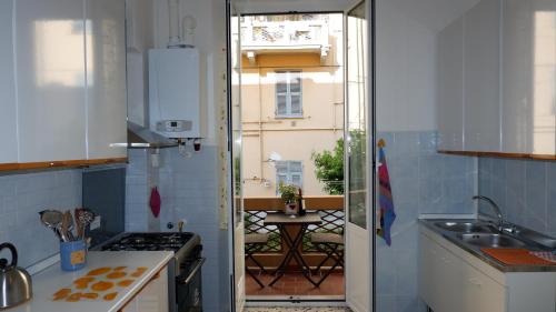 een keuken met een deur naar een balkon bij Aldo's house in La Spezia