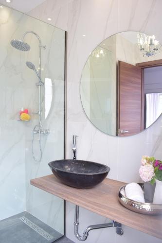a bathroom with a black sink and a mirror at Beach Side Apart II in Kavala