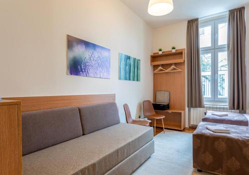 un soggiorno con un divano e un letto di Booking En Suite a Belgrado