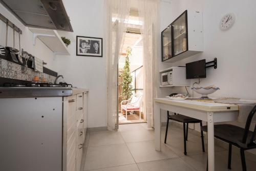 cocina con mesa y escritorio con microondas en Casa Andromaca, en Noto
