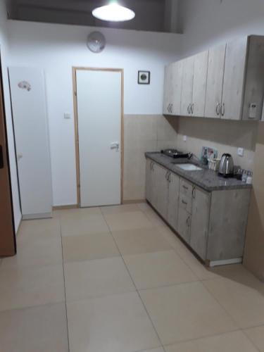 a kitchen with white cabinets and a counter top at Guest House Orlihome in Haifa