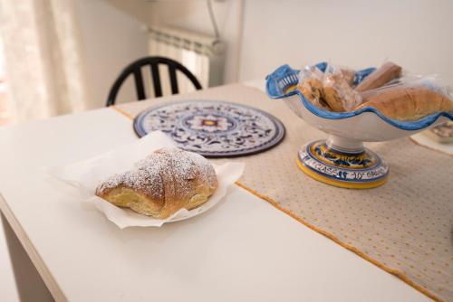 a table with a pastry and a bowl of bread at Casa Andromaca in Noto