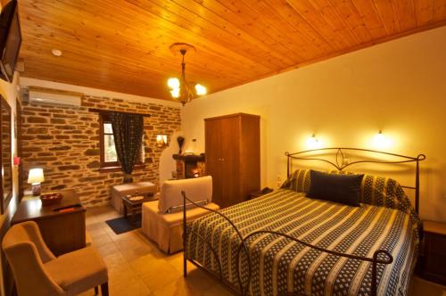 a bedroom with a bed and a brick wall at Archontiko Papoutsi in Mouresi
