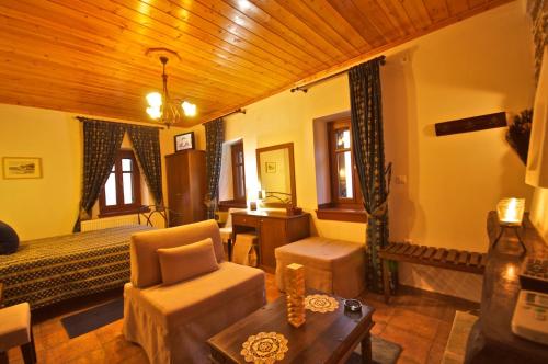 a bedroom with a bed and a chair and a table at Archontiko Papoutsi in Mouresi