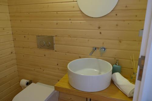 a bathroom with a white sink in a wooden wall at Casa Sulfato in Campo do Gerês