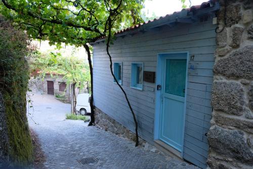 a building with a blue door on the side of it at Casa Sulfato in Campo do Gerês