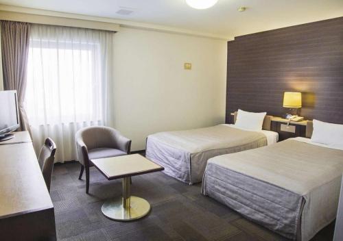 門真市にあるKadoma Public Hotel/ Vacation STAY 33574のベッド2台と椅子があるホテルの部屋