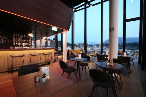 a restaurant with tables and chairs and a bar at arte Hotel Salzburg in Salzburg