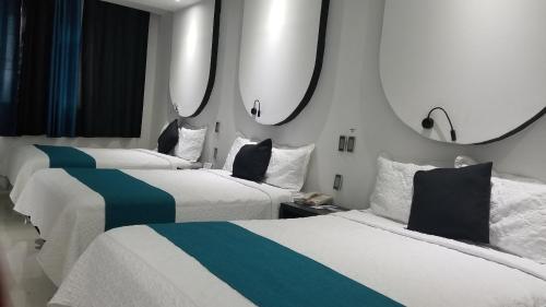 two beds in a hotel room with blue and white at Hotel Dluxe in San Juan de los Lagos