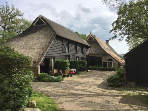 an old house with a thatched roof and a driveway at Eursingerhof in Havelte