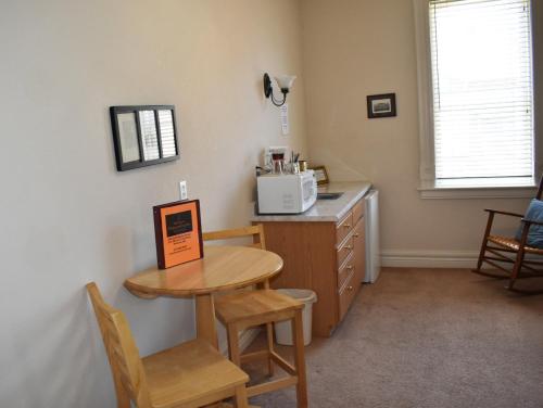 a kitchen with a table and a microwave on a counter at Hermann Crown Suites in Hermann