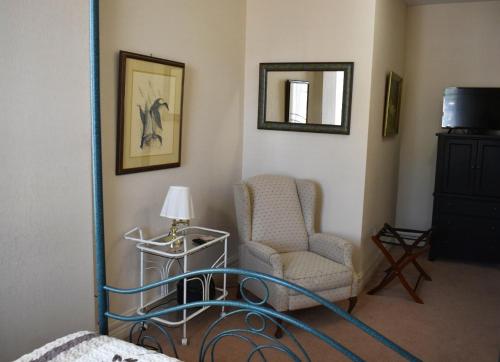 a room with a chair and a lamp and a mirror at Hermann Crown Suites in Hermann