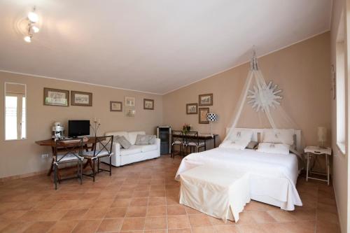 1 dormitorio con cama, mesa y sofá en Un Giardino sul Lago, en Montefiascone