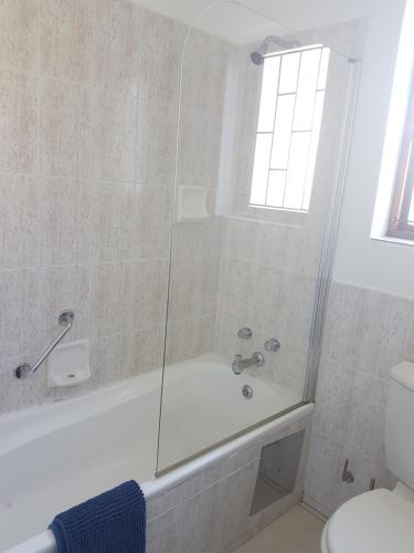 a bathroom with a shower with a tub and a toilet at Keurbooms River Lodge 21 in Keurboomstrand