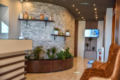 a lobby with plants on a brick wall at Padam Hotel & SPA in Ulcinj