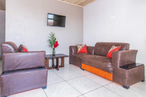a living room with two brown leather couches and a table at Casa Monarca - Monteverde in Monteverde Costa Rica