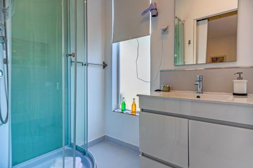 een badkamer met een glazen douche en een wastafel bij Privat Atelier in Setúbal