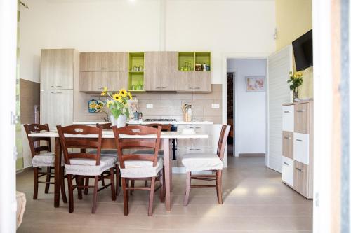 a kitchen and dining room with a table and chairs at Villetta Mari con piscina esclusiva nel Salento in Capilungo