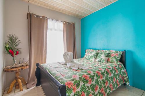 a bedroom with a bed and a blue wall at Casa Monarca - Monteverde in Monteverde Costa Rica