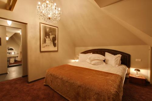 1 dormitorio con 1 cama grande y lámpara de araña en Villa Sterrebosch - boutique hotel - 1 suite - centrum Wijchen, en Wijchen