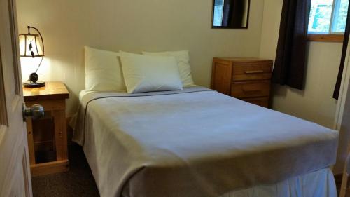 um quarto com uma cama grande e uma mesa de cabeceira em Logging Chain Lodge Cottage Resort em Dwight