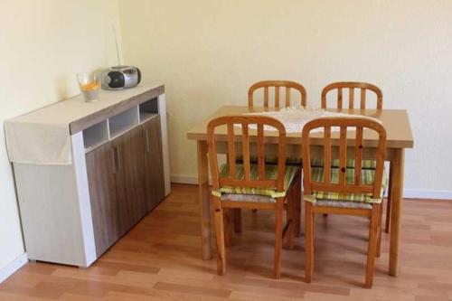 a dining room table with four chairs and a counter at Ferienhaus in Plogshagenauf Hidden in Neuendorf
