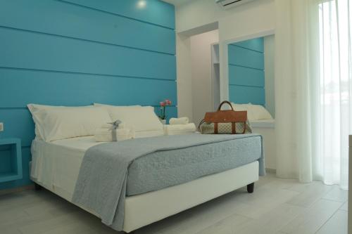 Schlafzimmer mit einem großen Bett mit blauem Kopfteil in der Unterkunft Dreams Tropea Mare in Tropea