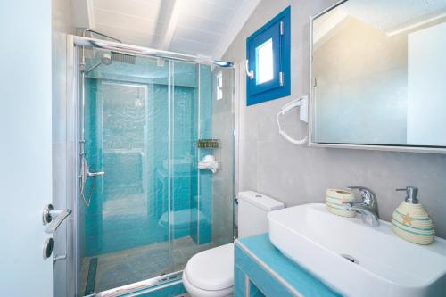 a bathroom with a shower and a toilet and a sink at GLAROS BUNGALOW in Skala Kallirachis