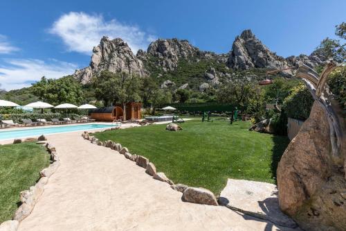 a resort with a mountain in the background at Antica Fonte Holiday Homes in San Pantaleo