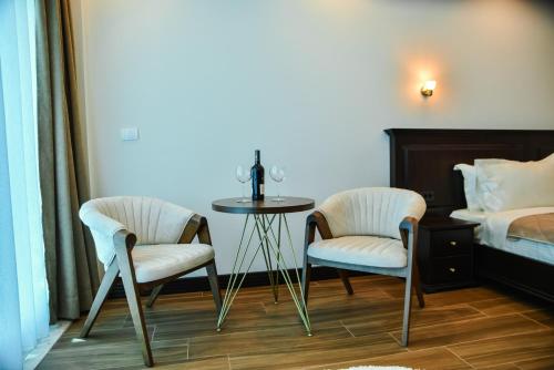 a bedroom with a table and two chairs and a bed at Padam Hotel & SPA in Ulcinj
