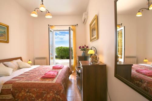 a bedroom with two beds and a mirror at Royal Holiday Apartments Sveti Stefan in Sveti Stefan