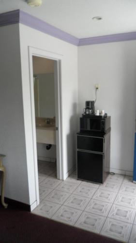 a room with a white wall and a black cabinet at Budget Inn of Lodi in Lodi