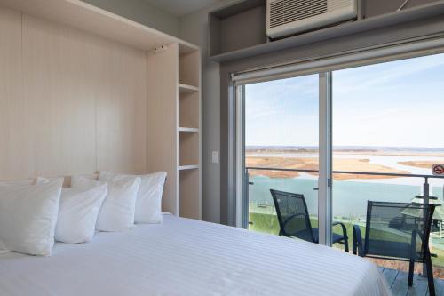 a bedroom with a bed and a large window at Micro Boutique Living Wolfville in Wolfville
