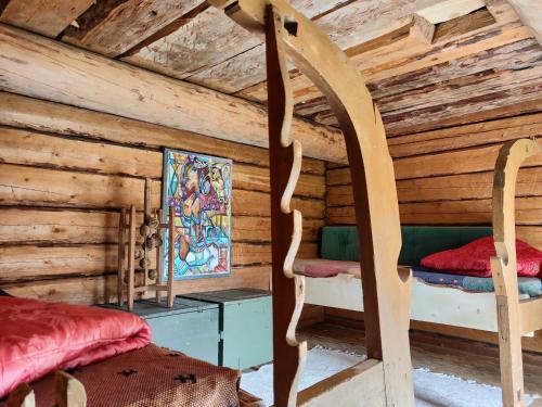 1 dormitorio en una cabaña de madera con 1 cama y sillas en Olo Tila en Kurikka