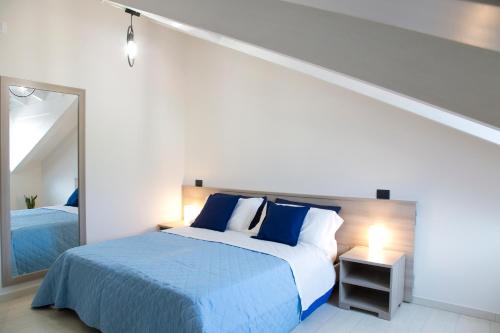 a bedroom with a blue bed and a mirror at Borgo12 in Pimonte