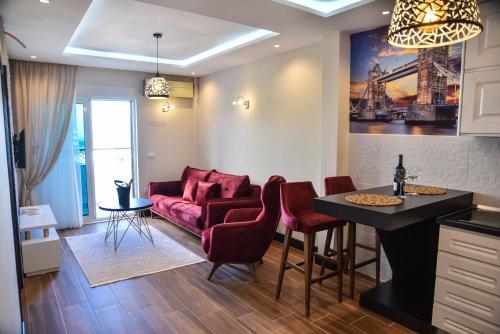 a living room with a red couch and a table at Padam Hotel & SPA in Ulcinj