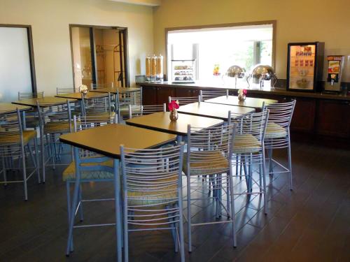 a group of tables and chairs in a restaurant at Eastland Suites Hotel & Conference Ctr, Trademark by Wyndham in Bloomington