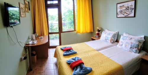 a bedroom with a bed with two towels on it at Guest House Maria in Nesebar