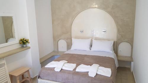 a bedroom with a bed with two towels on it at Pension The Big Blue in Katapola