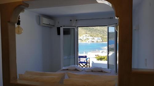 a bedroom with a bed and a view of the ocean at Pension The Big Blue in Katapola
