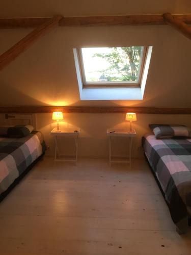 a attic room with two beds and a window at De Hocht in Nes