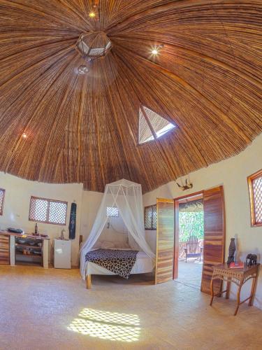 a bedroom with a bed with a wooden ceiling at Mundo Milo Eco Lodge in Playa Junquillal