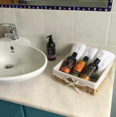 a bathroom counter with a sink and bottles on it at Villa Christina Anidri in Ánidhroi