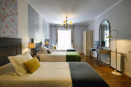 una camera d'albergo con due letti e una finestra di Charm Inn Sintra a Sintra