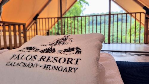 a pillow sitting on top of a chair on a balcony at Pálos Resort in Zalacsány